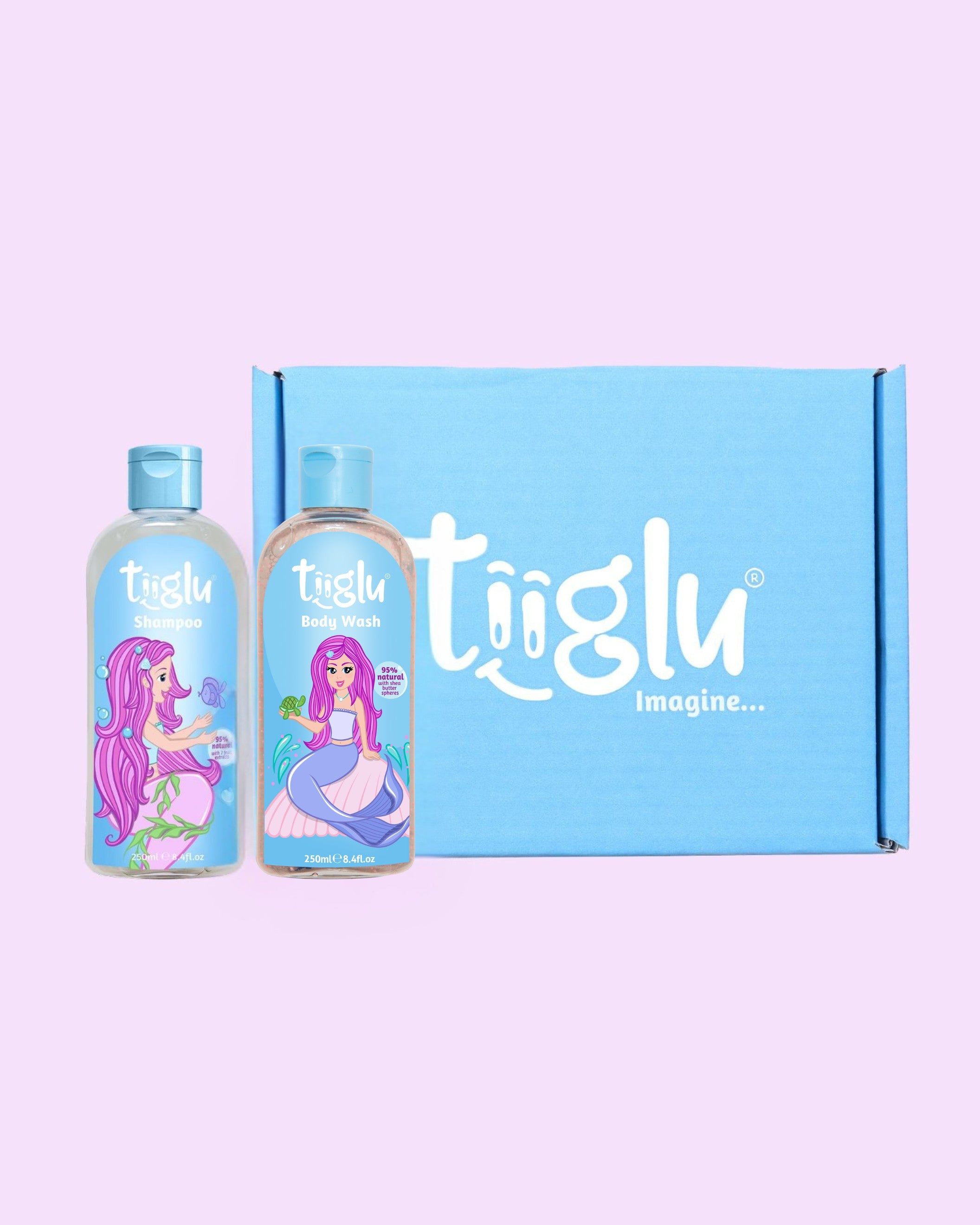 Tiiglu® Kids Mermaid Glimmer Set with Shampoo (95% natural) and Body Wash (95% natural), each 250ml, featuring a pink-haired mermaid on light blue labels, in a blue Tiiglu® gift box, on a light pink background.