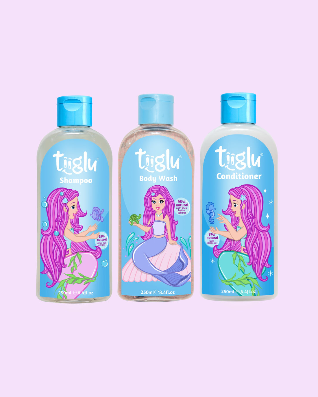 Tiiglu® Kids Mermaid Dazzle Set with Shampoo (95% natural), Body Wash (95% natural), and Conditioner (97% natural), each 250ml, featuring a pink-haired mermaid on light blue labels, jumping jelly beans-scented, on a light pink background.